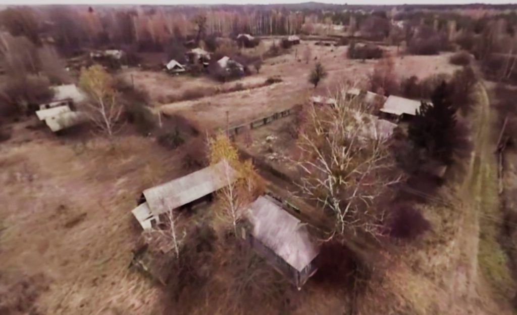 Aerial view of houses and rural buildings. The image is poor quality.