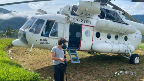 A person operating a 360 camera in front of a cargo transport helicopter