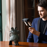 Man pointing a handheld 3d scanner at an object